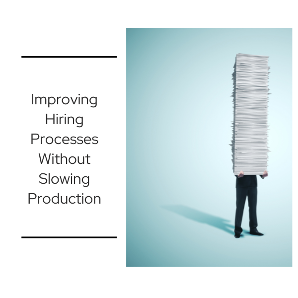 A person standing upright while balancing an oversized stack of papers that completely obscures their upper body, representing the administrative burden of inefficient hiring processes in manufacturing and industrial environments.