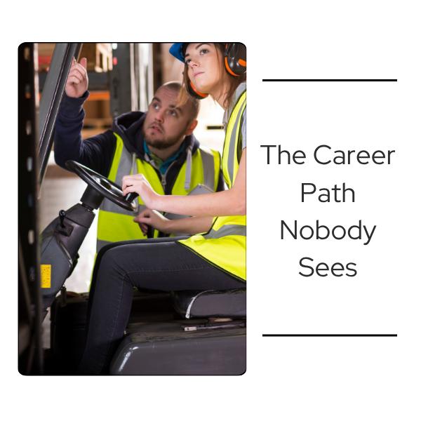 Trainer in a high-visibility vest guiding a worker in a hard hat and ear protection at the controls of a warehouse forklift.
